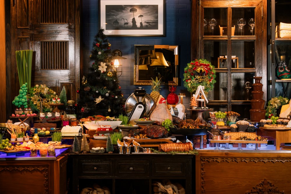 Buffet table with Christmas-themed desserts and tropical decorations