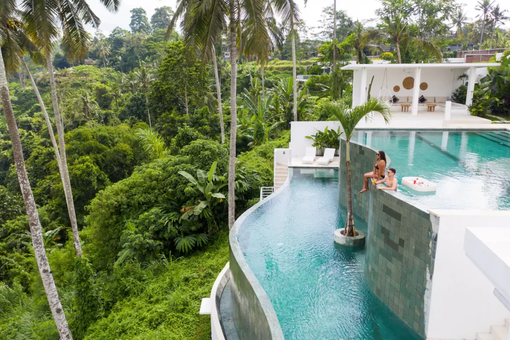 Villa in Ubud with infinity pool overlooking green forest.